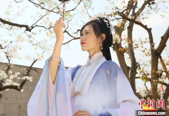 圖為蘭州青年身穿漢服在百年梨園賞景?！「哒?攝