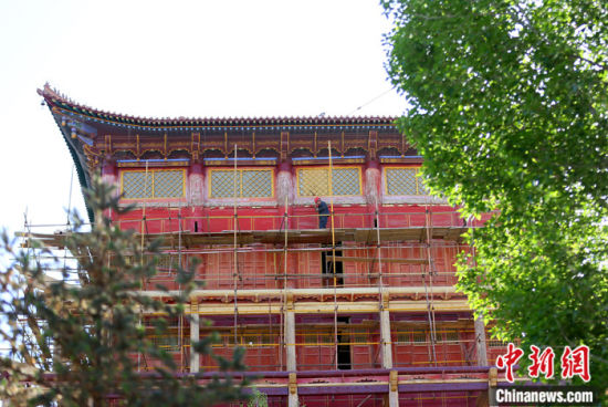 圖為5月上旬，甘肅山丹縣大佛寺內(nèi)，工作人員對(duì)古建筑大雄寶殿進(jìn)行修繕。 中新社記者 高展 攝