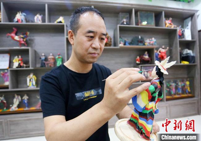圖為安秋平正在創(chuàng)作代表隴南文縣民俗的《白馬人》作品。　高展 攝