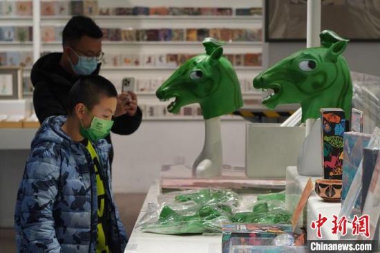 圖為“神馬來了”銅奔馬頭套吸引參觀者駐足?！【琶赖┰?攝