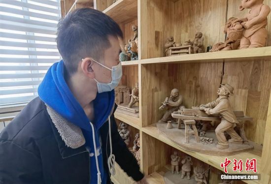 圖為學(xué)生欣賞泥塑作品。 劉玉桃 攝