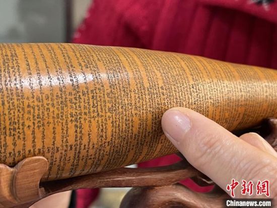 圖為長約二十公分的長條葫蘆雕刻佛教經(jīng)文作品?！堟?攝