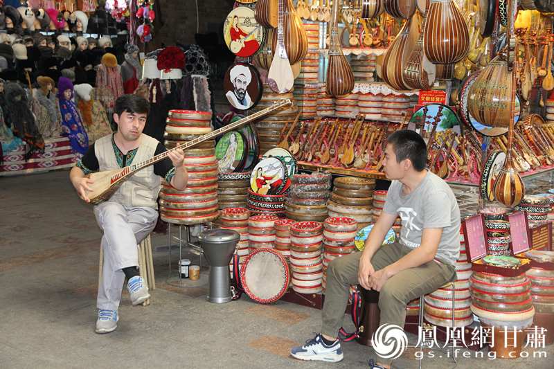 烏魯木齊二道橋巴扎內(nèi)，店主正在向客人展示樂器。楊文遠(yuǎn) 攝
