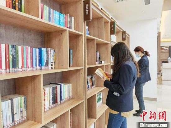 圖為在甘肅公航旅建設(shè)集團有限公司的職工書屋，職工挑選書籍。　徐雪 攝