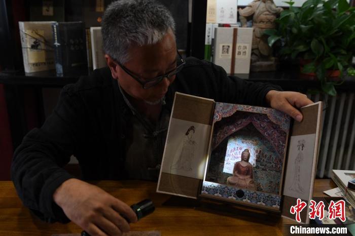 圖為讀者出版集團讀者晉林工作室獨立出品人徐晉林，展示互動性強的敦煌題材手工書。(資料圖) 楊艷敏 攝
