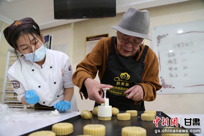 當(dāng)日，受邀參加活動的臺胞臺屬代表、兩岸婚姻及子女、在甘臺商代表等歡聚一堂。圖為77歲的在甘臺胞潘天鑒制作月餅。九美旦增 攝