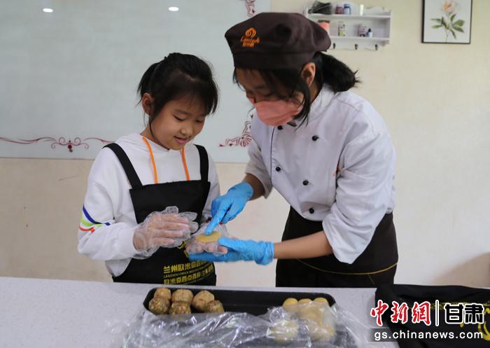 圖為在甘臺胞小朋友在工作人員指導(dǎo)下制作月餅。九美旦增 攝