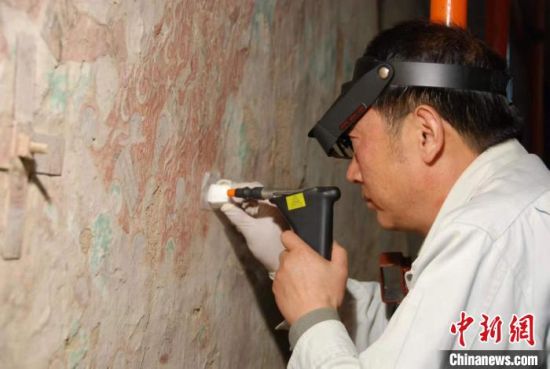 敦煌研究院研究員樊再軒進行壁畫修復。(資料圖)張云文 攝