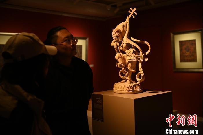 圖為季茂杰向參觀者介紹自己創(chuàng)作敦煌木雕的過程。李亞龍 攝</p>
<p>