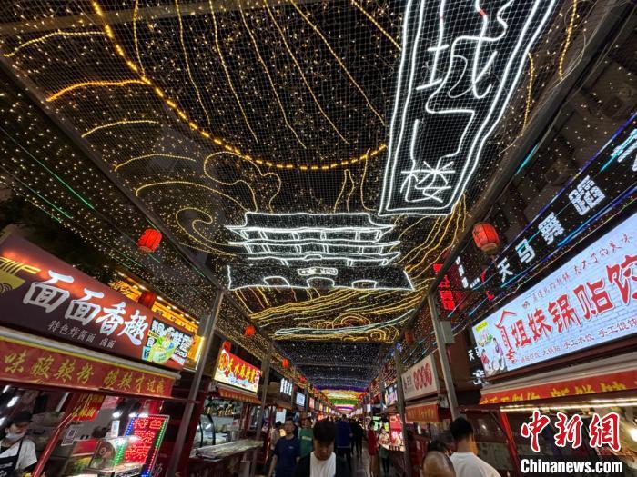 圖為明清街夜市燈光點亮具有武威文化元素的“涼州古城門”彩燈。　戴文昌 攝</p><p>