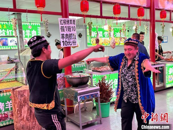 圖為餐飲經(jīng)營者在“西涼不夜城”跳起舞蹈引客。　戴文昌 攝</p><p>